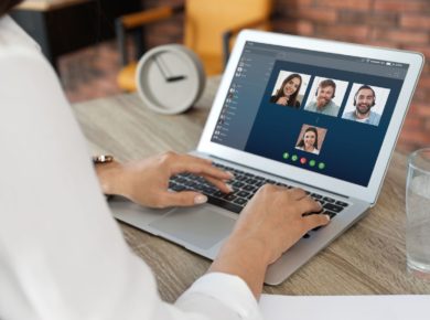 Bilgisayarı ile iş arkadaşları ile görüntülü konuşma gerçekleştiren kadın