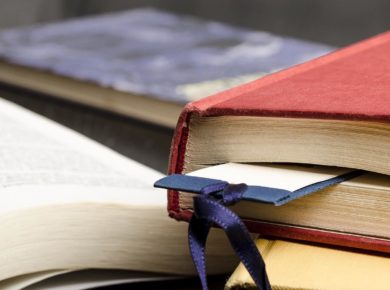 Eski kırmızı bir kitabın arasında konmuş kitap ayracı