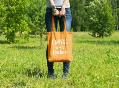 Elinde üzeri yazılı sarı bez çanta tutan bir kadın görseli