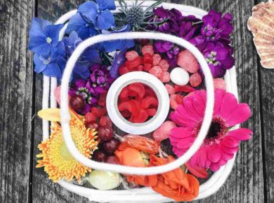 Renkli çiçeklerin bir araya getirilmesi ve üzerine beyaz daireler konmasıyla oluşturulmuş Instagram logosu görseli